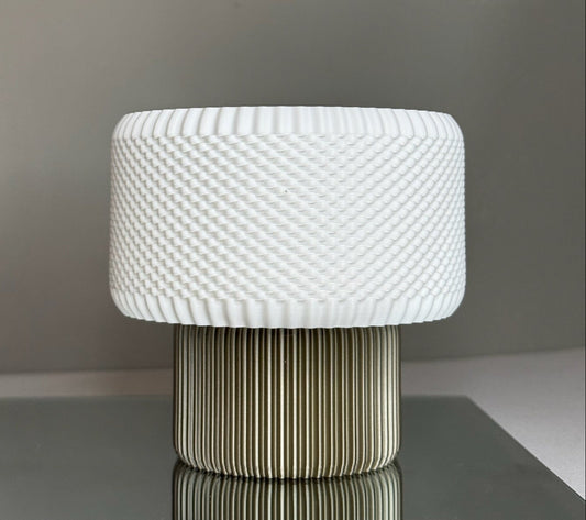 White textured table lamp on a dark surface with a neutral background